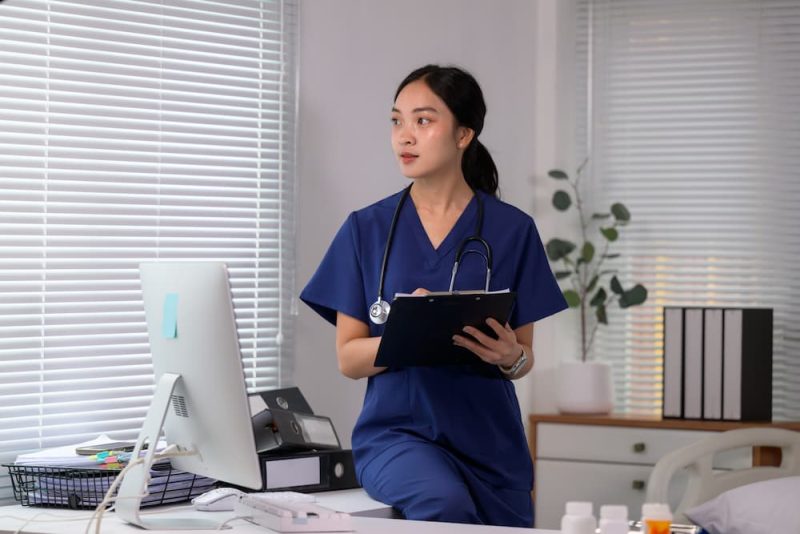 Nurse holding a clipboard and writing SOAP notes in a medical office